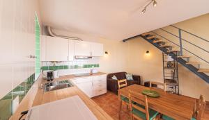 eine Küche mit einem Waschbecken, einem Tisch und einer Treppe in der Unterkunft Páteo dos Oliveira - Casa da Cocheira in Évora