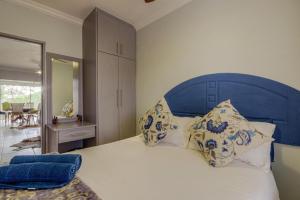 a bedroom with a blue headboard with pillows on a bed at The Bridge Apartments, Unit 34 in St Lucia