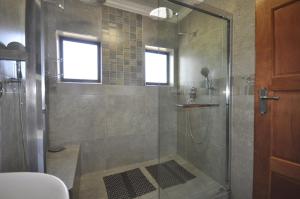 a shower with a glass door in a bathroom at The Bridge Apartments, Unit 34 in St Lucia