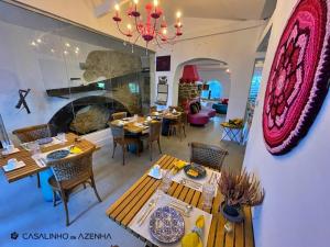 a restaurant with tables and chairs and a fireplace at Casalinho da Azenha - Charm House in Sintra