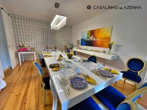 jadalnia z długim stołem i niebieskimi krzesłami w obiekcie Casalinho da Azenha - Charm House w mieście Sintra