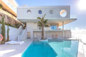 uma casa com uma piscina em frente em Ensuite Deluxe Jacuzzi & Parking Privado em Fuengirola