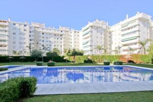 a swimming pool in front of some apartment buildings at Loft Miramar in Fuengirola