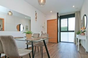 Un comedor con una mesa de cristal y sillas. en Loft Miramar, en Fuengirola