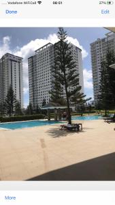 a picture of a park with a tree and some buildings at A&B Condo with Netflix at SMDC Wind Residences in Tagaytay