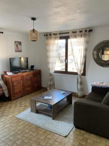 sala de estar con sofá y mesa de centro en Location appartement 4 couchages en rez de jardin, en La Cabanasse