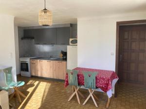 una cocina con una mesa con un mantel rojo. en Location appartement 4 couchages en rez de jardin en La Cabanasse