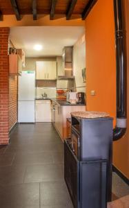 a kitchen with orange walls and a white refrigerator at Cerca del puerto deportivo y de la playa in Cangas de Morrazo