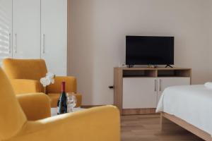 a bedroom with a bed and two chairs and a television at La Casa M in Vršac