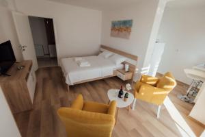 a living room with a bed and two chairs and a table at La Casa M in Vršac