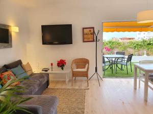 a living room with a couch and a table at Cozy and intimate bungalow in Puerto de la Cruz in Puerto de la Cruz