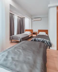 a bedroom with two beds and a window at Motel Almy in Zenica