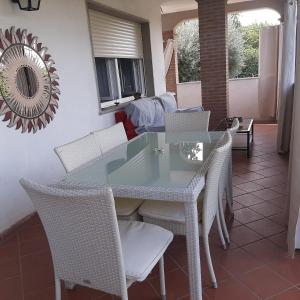 a glass table and chairs on a patio at Kevin House in Marlia