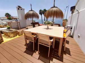 a wooden deck with a table and chairs and the ocean at Suite Deluxe Face Mer Apart Malaga in Málaga