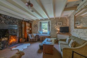 sala de estar con sofá y chimenea en Heart of Glencoe Holidays en Glencoe
