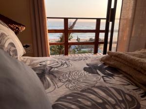 a bedroom with a bed with a view of the beach at Bamboo Room in Ponta do Ouro