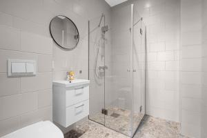 een badkamer met een douche, een toilet en een wastafel bij Forenom Serviced Apartments Drammen in Drammen