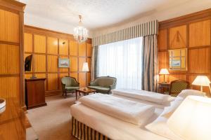 a hotel room with two beds and a chair at Hotel König von Ungarn in Vienna