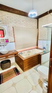 uma casa de banho com uma banheira, um WC e um lavatório. em Conforto e Lazer é na Casa Bali em Ribeirão Preto