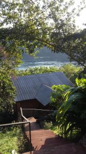 une maison avec un toit en métal et un escalier dans l'établissement Stone Wall Cottages, à Puerto Iguazú