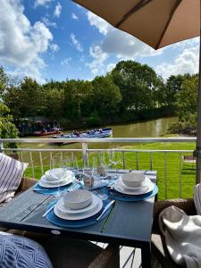 a blue table with plates and glasses and a view of a river at Grachtensteern in Greetsiel