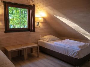 niewielka sypialnia z łóżkiem i oknem w obiekcie Ośrodek Wypoczynkowy Laguna w Lubniewicach