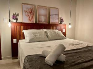 a bedroom with a large bed with white sheets and pillows at Pousada Recanto Nalu - Quarto à Vista in Pipa