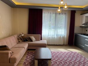 een woonkamer met een bank en een tafel bij Karadeniz Apart Otel in Uzungol
