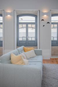 a living room with a blue couch with pillows at Liiiving in Porto - Santa Catarina Twin Apartments in Porto