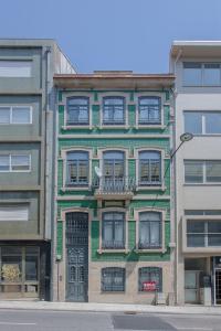 a green building with a balcony on a street at Liiiving in Porto - Santa Catarina Twin Apartments in Porto