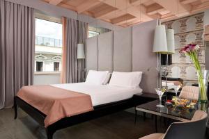 een slaapkamer met een bed, een tafel en een raam bij Leon's Place Hotel In Rome in Rome