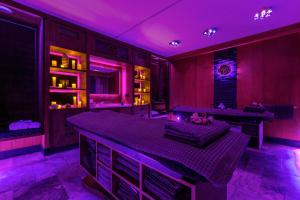 Habitación con iluminación púrpura y mesa. en Mała Anglia Deluxe Rooms & SPA, en Sopot