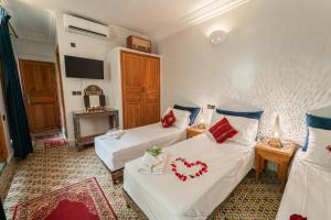 a hotel room with two beds with hearts on them at Riad Taj Salma in Fez