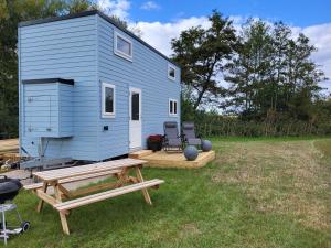a blue tiny house with a picnic table and chairs at Bracken Heights in Newark-on-Trent
