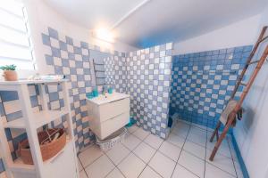 a bathroom with a toilet and a blue tiled wall at Studio CASSIA en RDJ proche lagon de l'Ermitage in Saint-Gilles les Bains