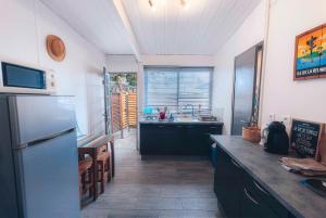 a kitchen with a stainless steel refrigerator and a table at Studio CASSIA en RDJ proche lagon de l'Ermitage in Saint-Gilles les Bains