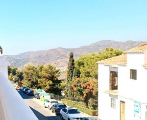 una calle con coches estacionados en un estacionamiento en Limerencia: tu hogar en este blanco pueblo, en Frigiliana