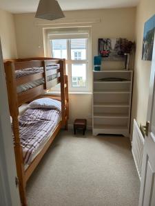 a bedroom with two bunk beds and a window at Ballycastle, Strand Cottages Modern Home in Ballycastle