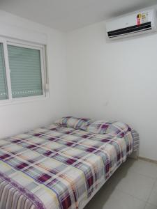 a bed in a white room with a window at Flat 404 Villa Hipica in Gravatá