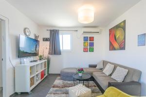 a living room with a couch and a tv at The Private House רשת הבית הפרטי in Beer Sheva