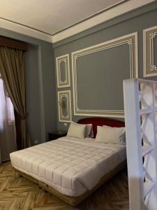 ein Schlafzimmer mit einem großen weißen Bett mit großem Rahmen in der Unterkunft Cosmopolitan hotel in Kairo