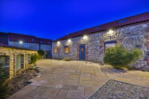 un edificio de piedra con patio por la noche en Immaculate 4-Bed Cottage in Lincoln en Sudbrooke