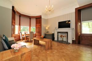 a living room with a fireplace and a table at Signature - Linden House Flat 1 in Airdrie