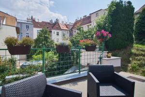 プラハにあるCozy Apartments with Terrace near Prague Castleのバルコニー(椅子2脚、鉢植えの植物付)