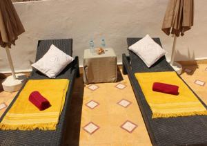 two chairs with pillows and a table in a room at Riad de charme l'Oasis d'Essaouira - Suite Luxe in Essaouira