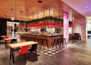 a bar in a restaurant with wooden tables and chairs at citizenM Chicago Downtown in Chicago