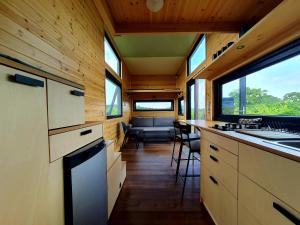 a kitchen in a tiny house with a sink and a stove at POP Tiny House Balaton in Káptalantóti