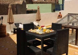 a table with food and drinks on a balcony at Riad de charme l'Oasis d'Essaouira - Chambre Luxe in Essaouira