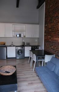 una cucina e un soggiorno con divano e tavolo di Daddy Long Legs Self Catering Apartments a Città del Capo
