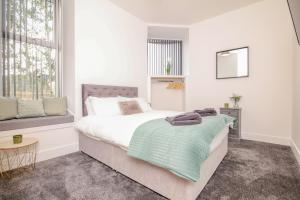 biała sypialnia z łóżkiem i oknem w obiekcie Mansfield Bar w mieście Hawick